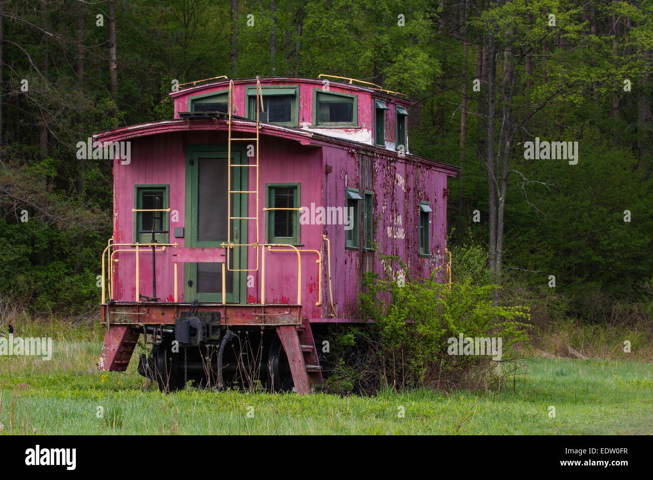 A pink caboose sits abandoned in a field Stock Photo Alamy
