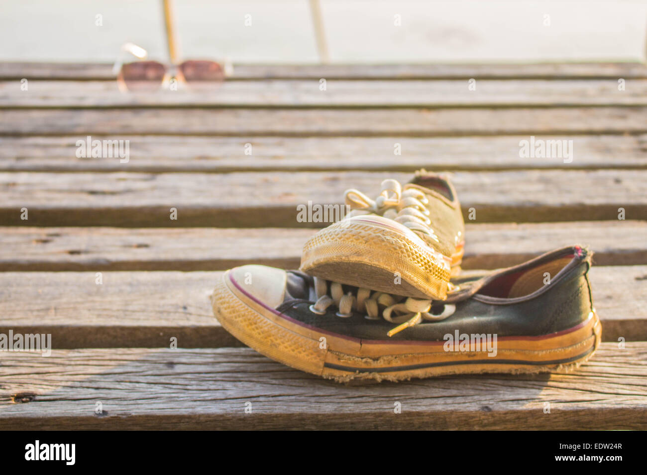 Old sneakers placed on the wooden floor Stock Photo - Alamy