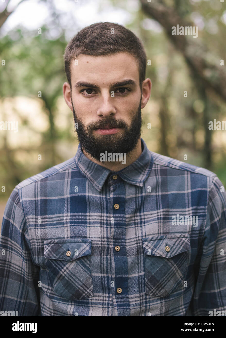Hipster man portrait outdoors. Man is looking at camera. Stock Photo