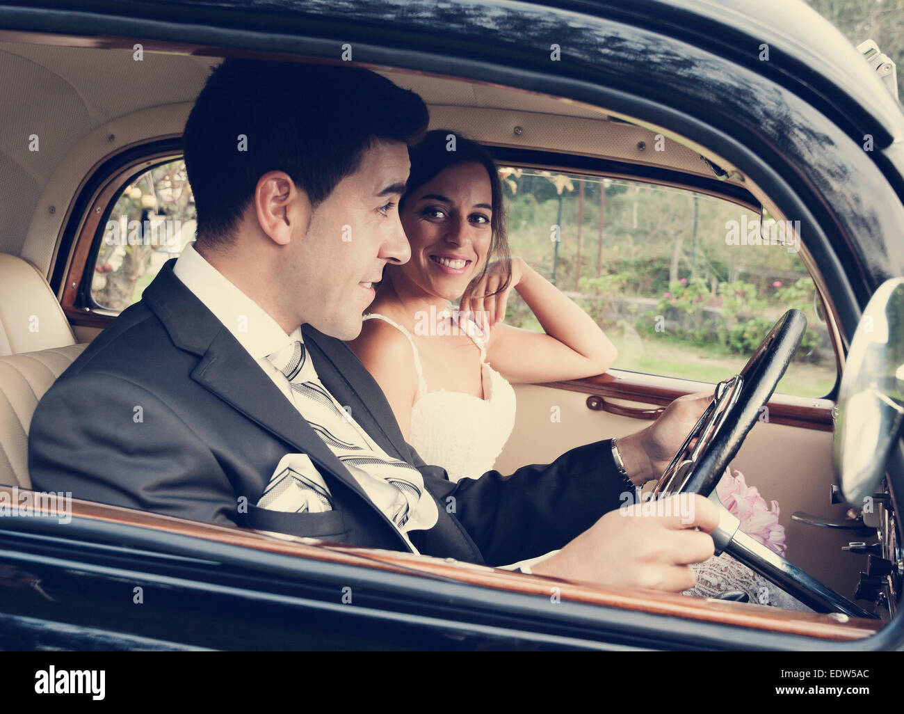 Bride and groom inside a classic car. They are happy Stock Photo - Alamy