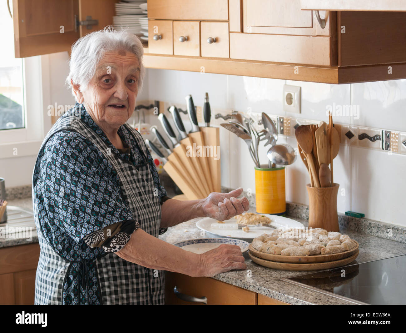 Elderly woman preparing croquettes at home Stock Photo