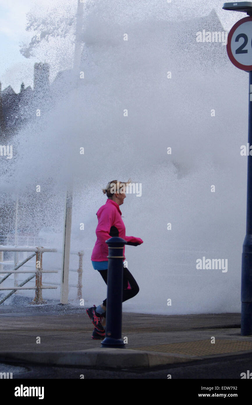 Aberystwyth, Wales, UK. 10th January, 2015. UK weather.  A jogger gets caught out by one of the huge waves smashing into the sea wall in Aberystwyth as storms hit the UK Credit:  Jon Freeman/Alamy Live News Stock Photo