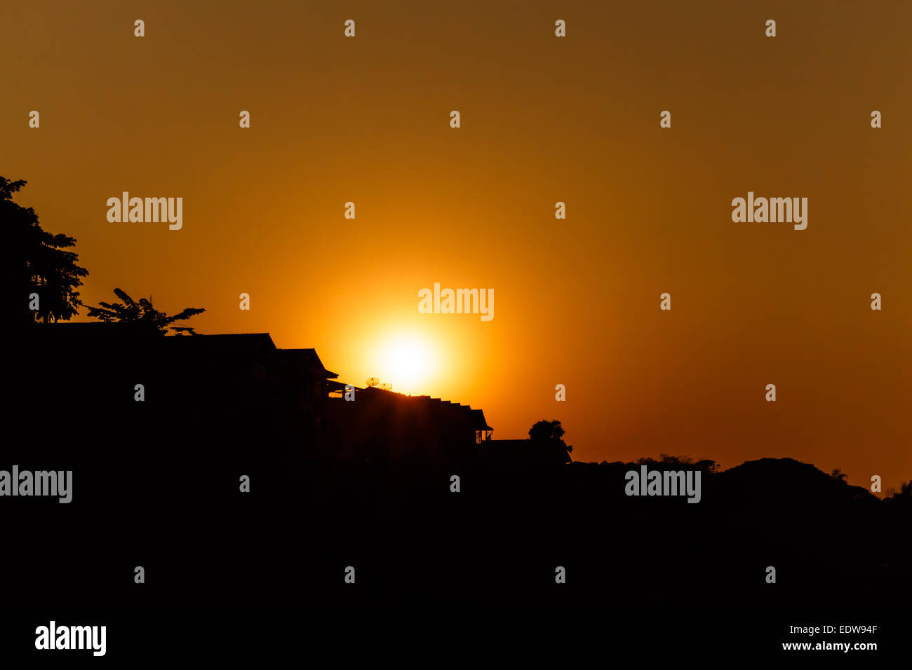 sunset above roof of house in rural scene (silhouette) at Chiang Khan ,Thailand Stock Photo
