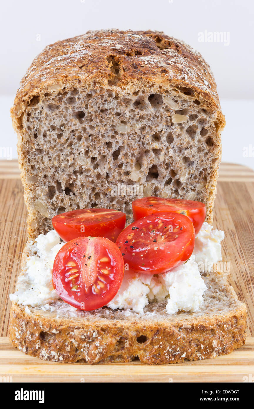 Closeup of slice of wholemeal bread with cottage cheese and cherry tomatoes Stock Photo