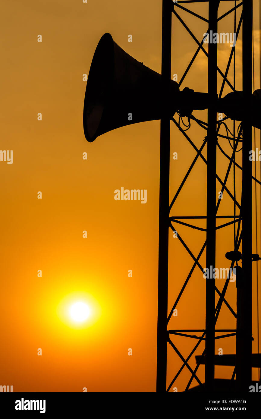 loudspeaker on pillar and sunset in the evening (silhouette) in Thailand Stock Photo