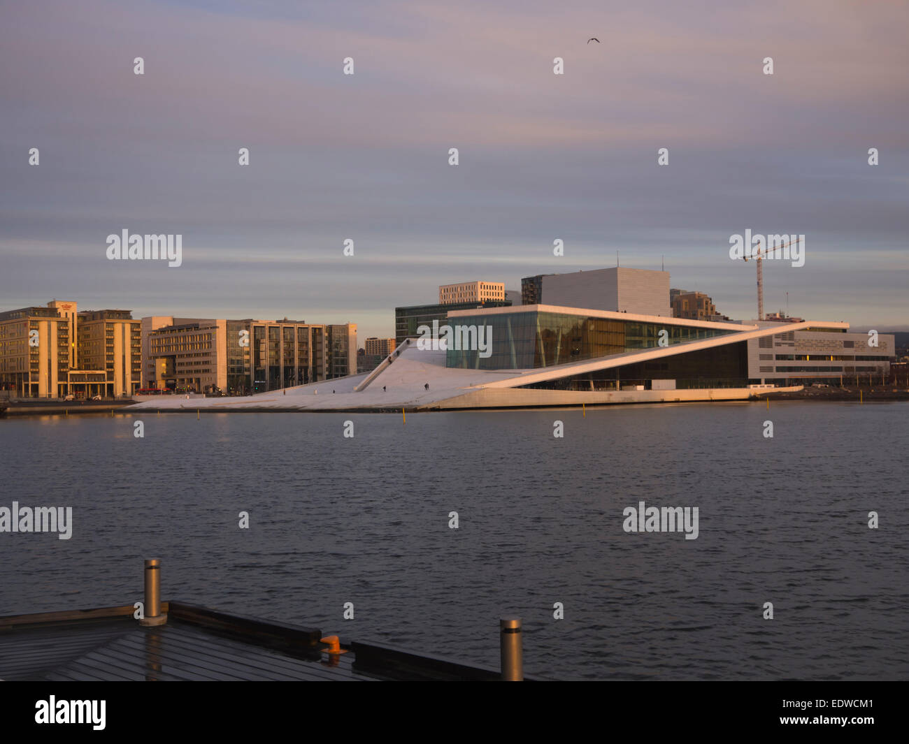 Oslo Norway, opera house in front of Barcode business district in low golden winter sun, architects Snøhetta Stock Photo