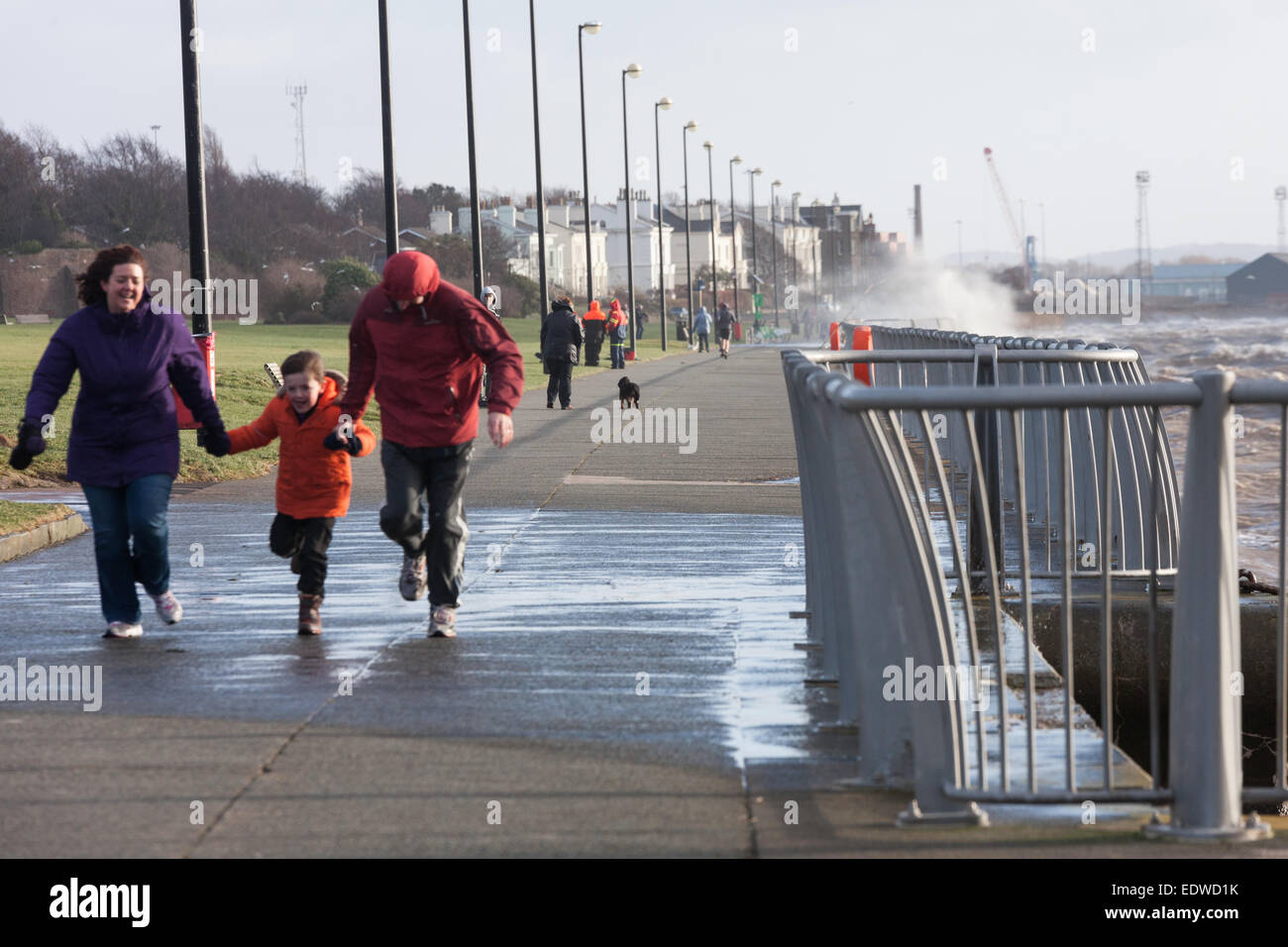Liverpool, Merseyside, UK. 10th January, 2015. A family run to avoid getting soaked by waves at Otterspool Promenade, Liverpool Credit:  Adam Vaughan/Alamy Live News Stock Photo