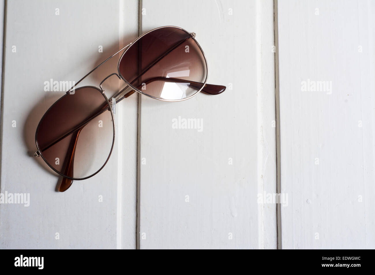 Sunglasses with brown glass on white wooden background Stock Photo