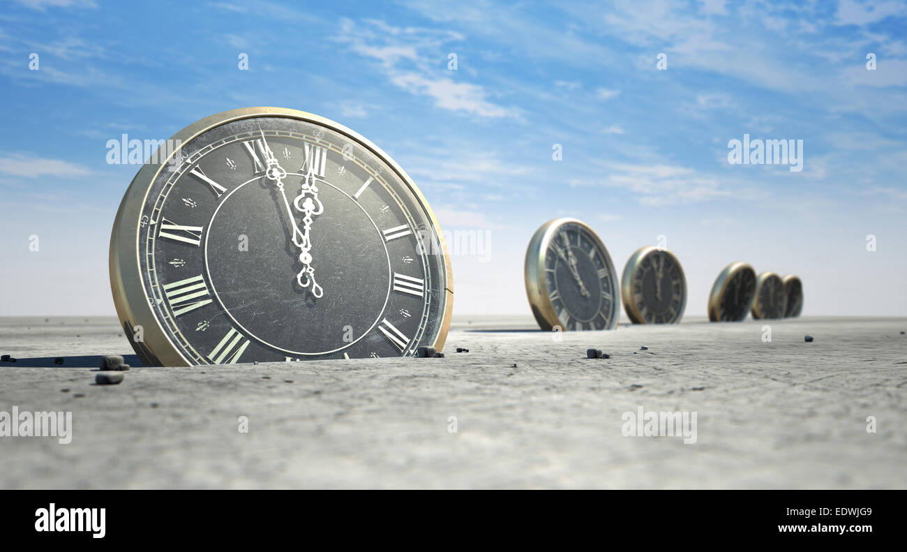 An array of half buried antique clocks scattered across a sandy desert landscape under a blue sky Stock Photo