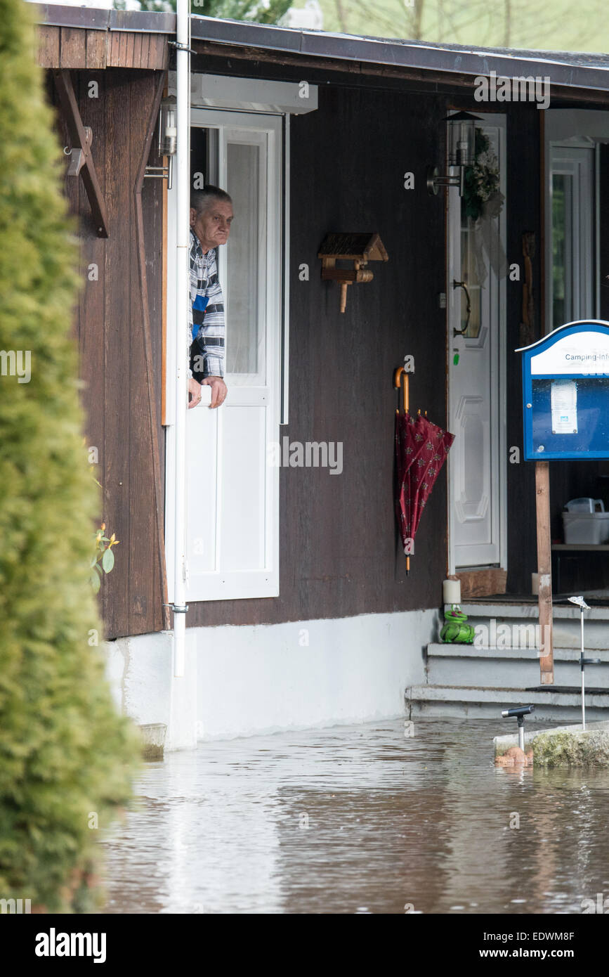 Bad Koetzting, Germany. 10th Jan, 2015. A man looks out of the window of a house at a campsite flooded by the Weisser Regen river in Bad Koetzting, Germany, 10 January 2015. First floodings occured in Northern and Eastern Bavaria. For the weekend, the German Meteorological Service has announced more thaw. PHOTO: ARMIN WEIGEL/dpa/Alamy Live News Stock Photo