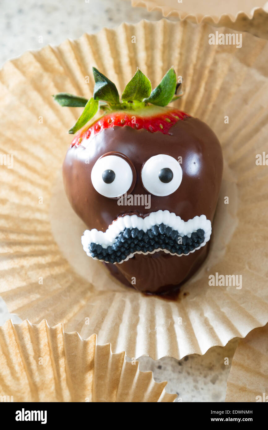 chocolate covered strawberry hand dipped and decorated with eyes and a mustache Stock Photo