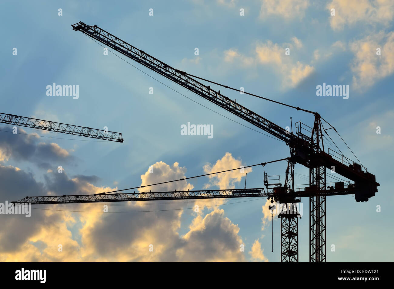 Silhouettes of construction cranes on the sky Stock Photo - Alamy