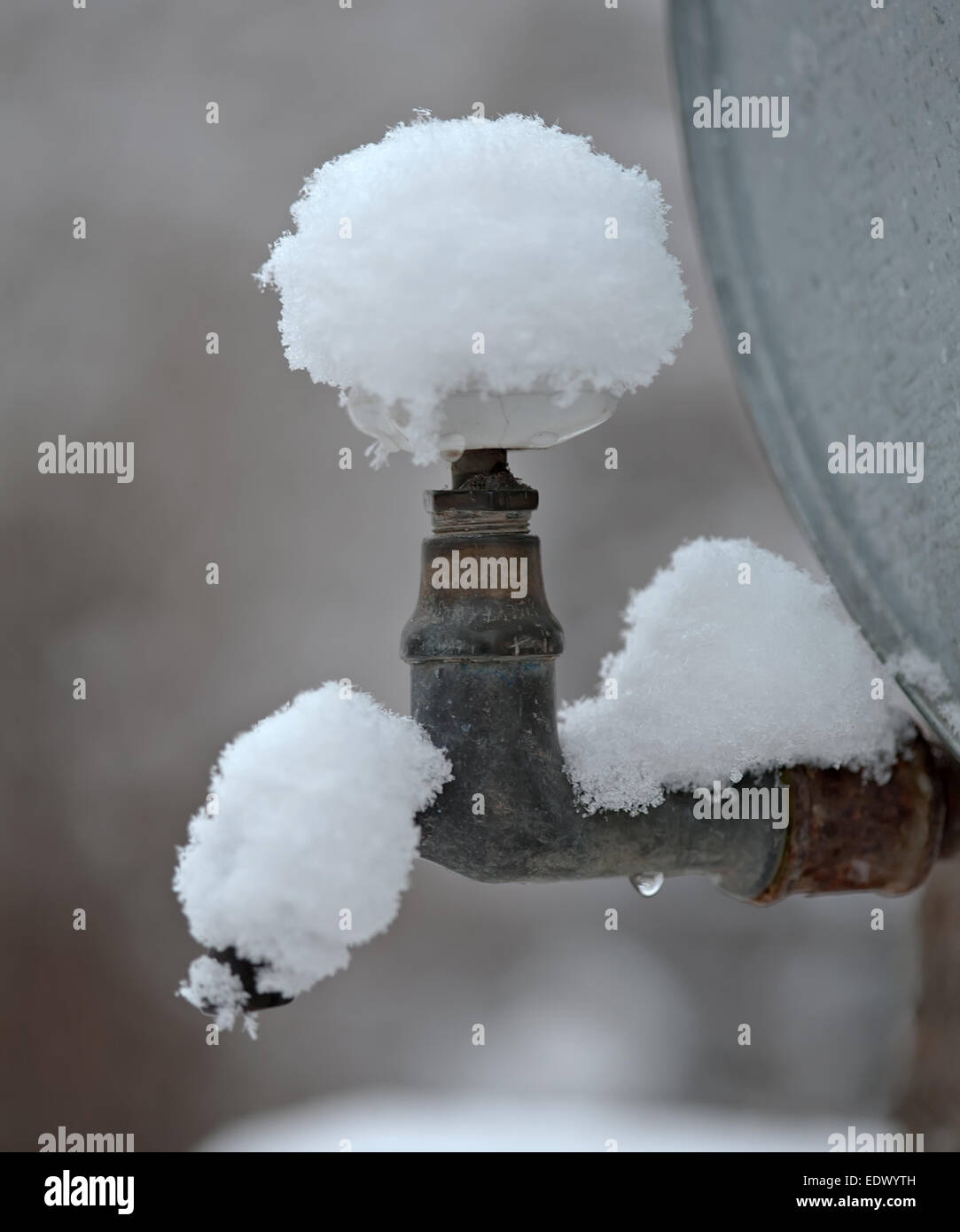 outdoor metal water supply faucet covered by snow Stock Photo