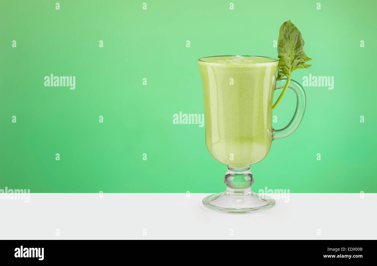 Green Smoothy in the glass on green background Stock Photo