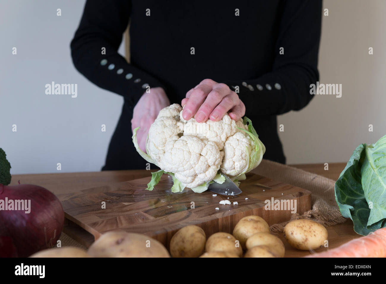 A womans hands slicing Cauliflower for a recipe. Stock Photo