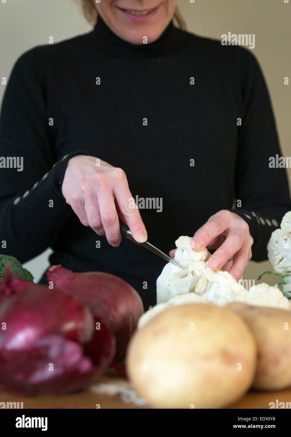 A womans hands slicing vegetables for a recipe. Stock Photo