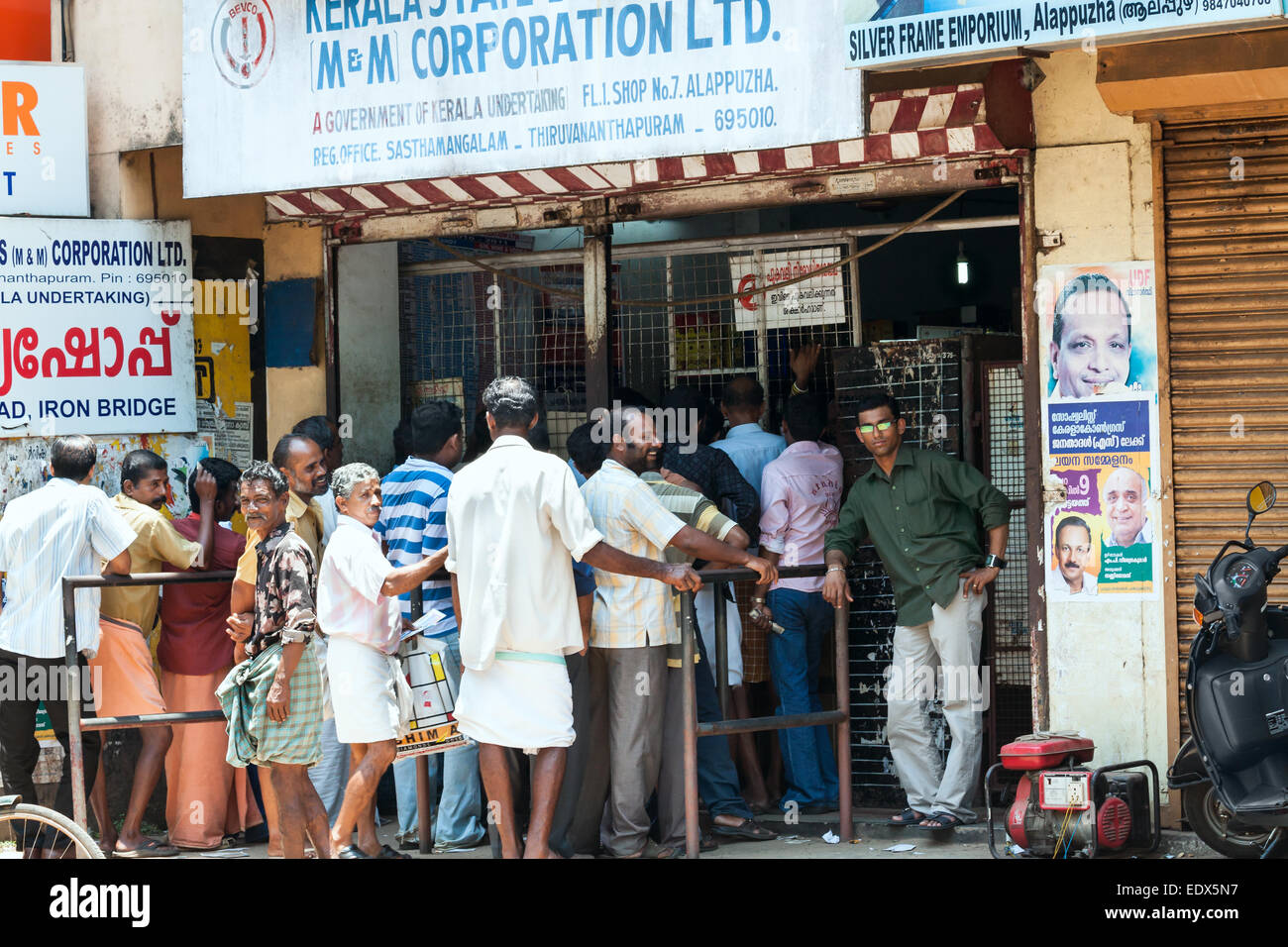 Indian men on queue waiting to buy alcohol from government-controlled shop in Alappuzha, Kerala state, India. Stock Photo