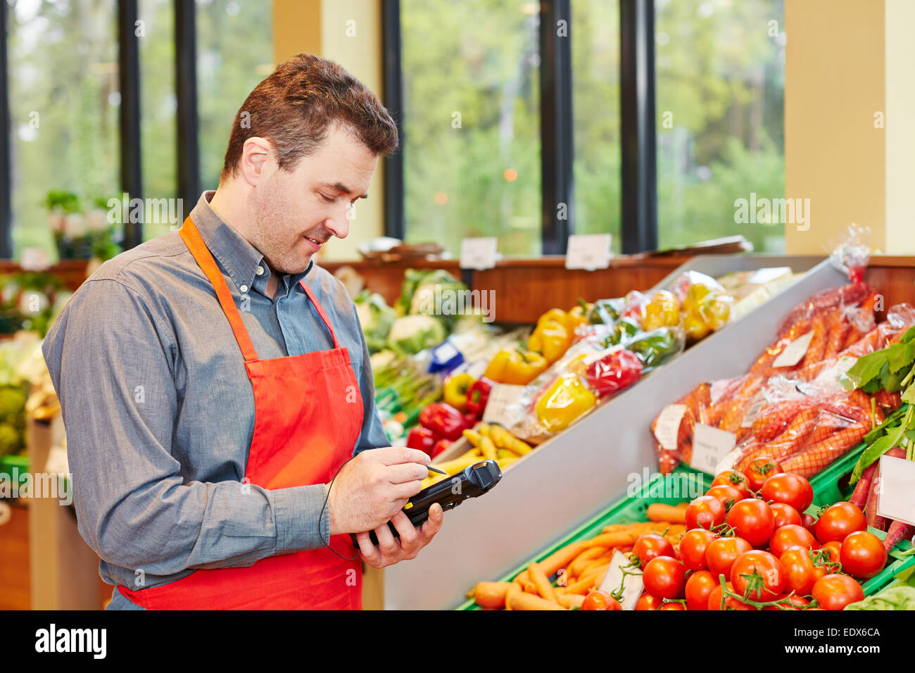 Store manager in supermarket using a mobile data registration terminal Stock Photo