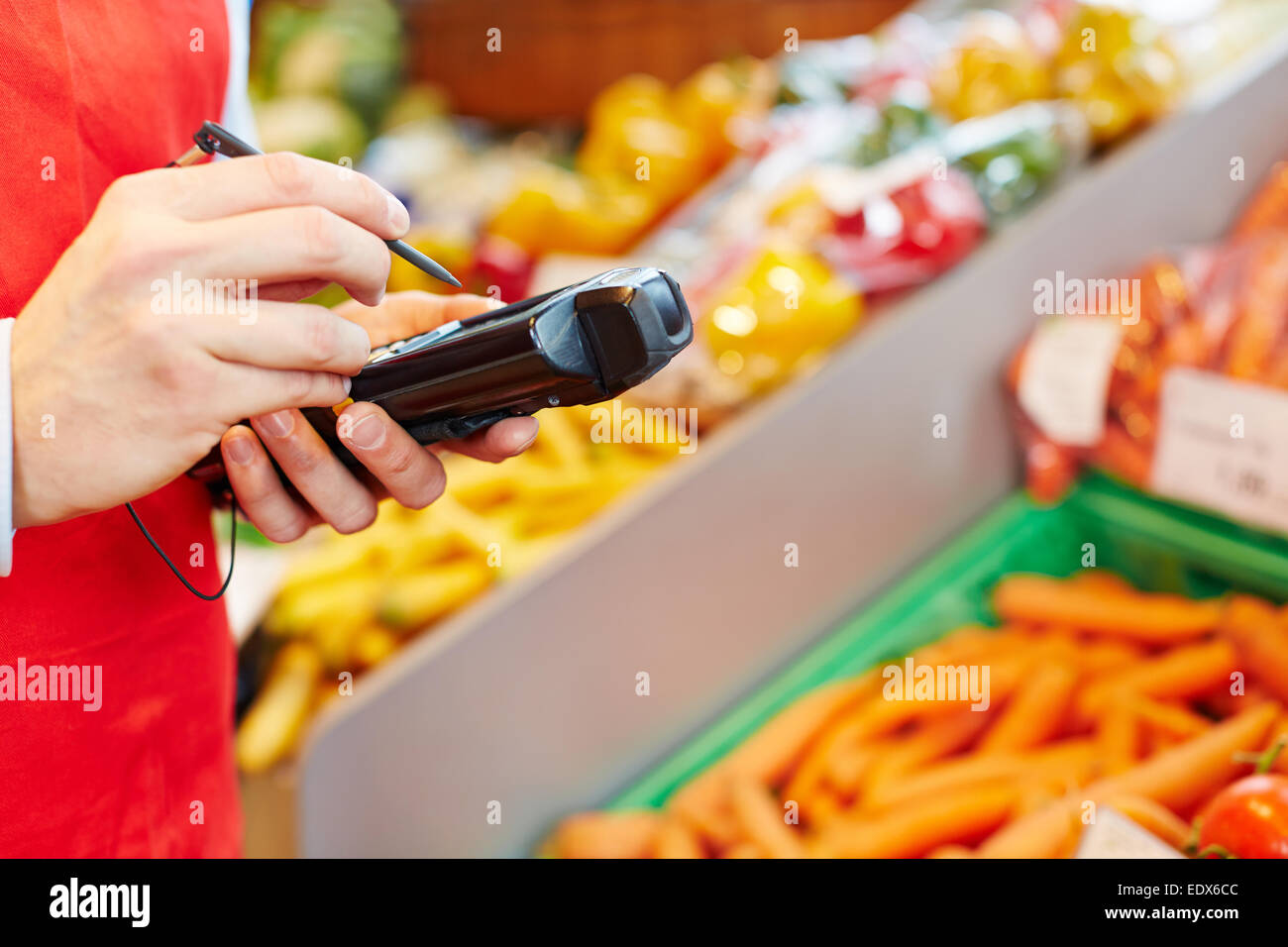 Hand holding mobile data registration terminal in a supermarket Stock Photo