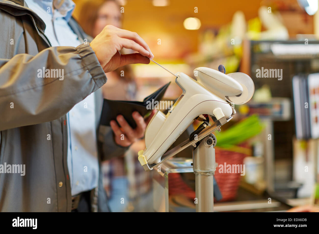 Man paying with credit card at supermarket checkout Stock Photo
