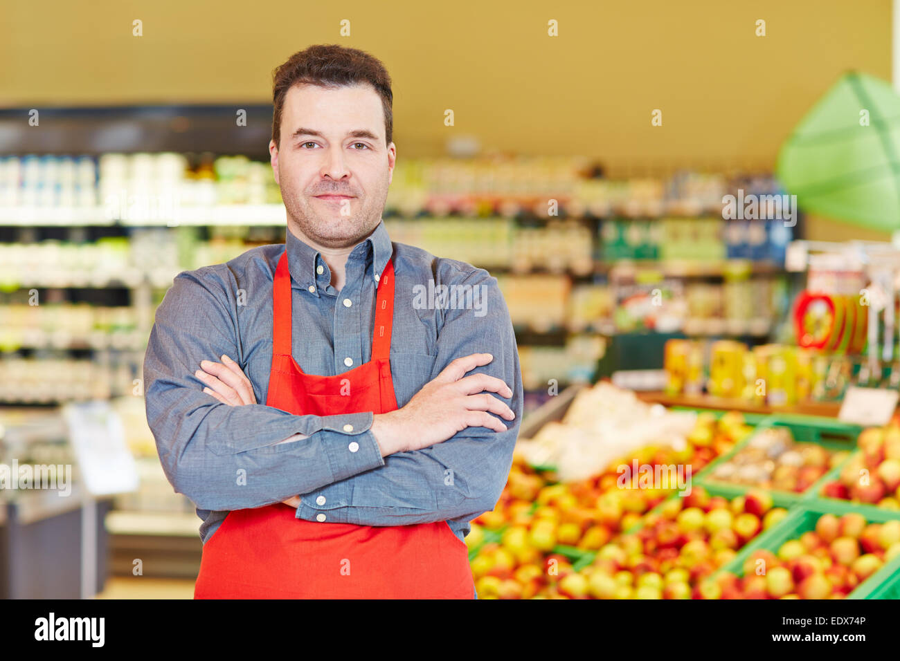 Store manager standing with his arms crossed in a supermarket Stock Photo
