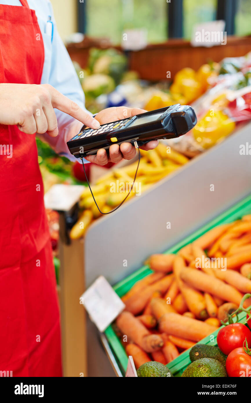 Finger typing on mobile data registration terminal in a supermarket Stock Photo