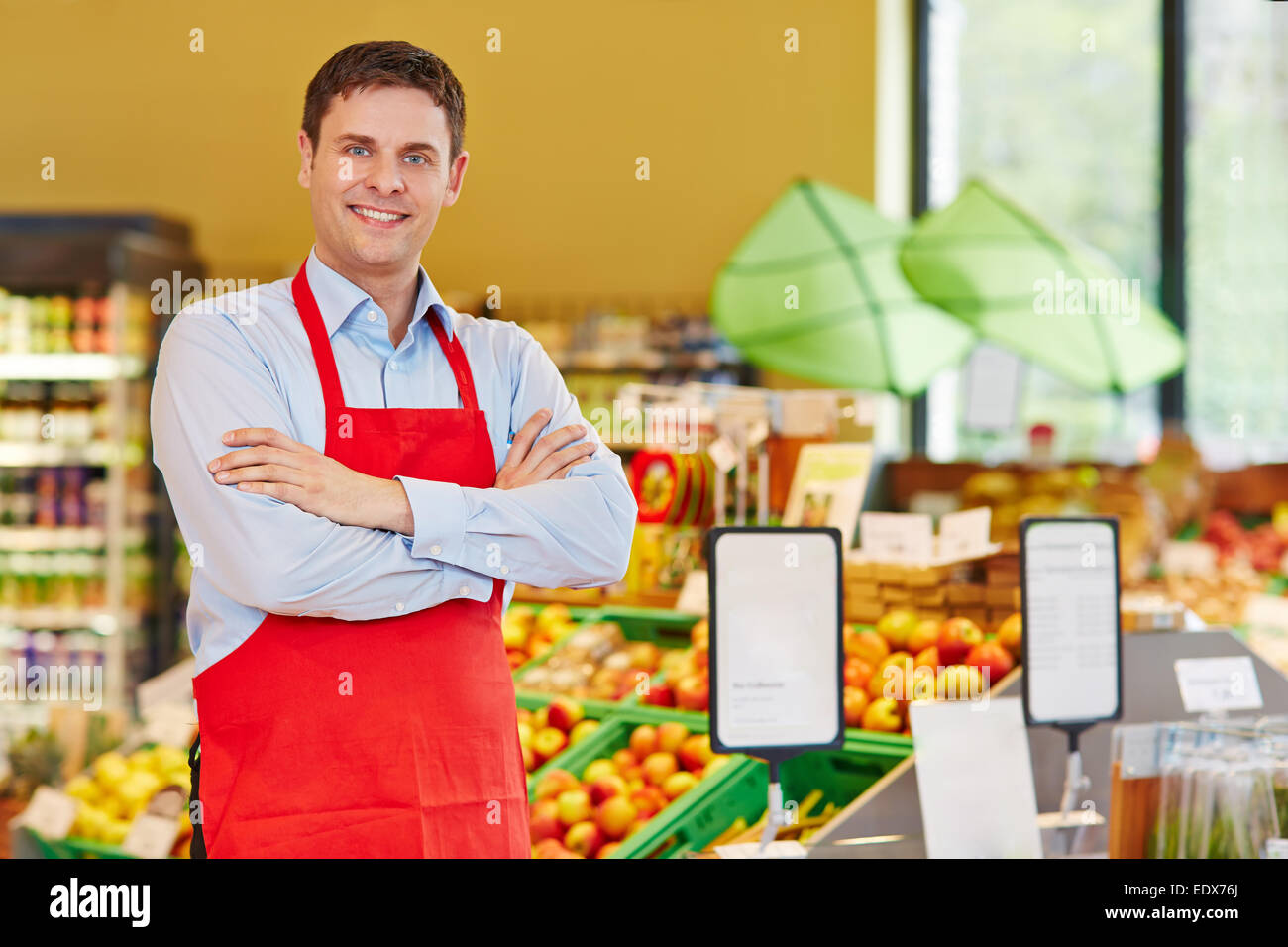 Happy store manager in supermarket with his arms crossed Stock Photo