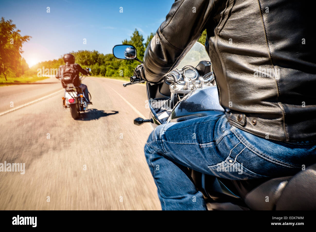 Bikers driving a motorcycle rides along the asphalt road (blurred motion). First-person view. Focus on the dashboard of a motorc Stock Photo