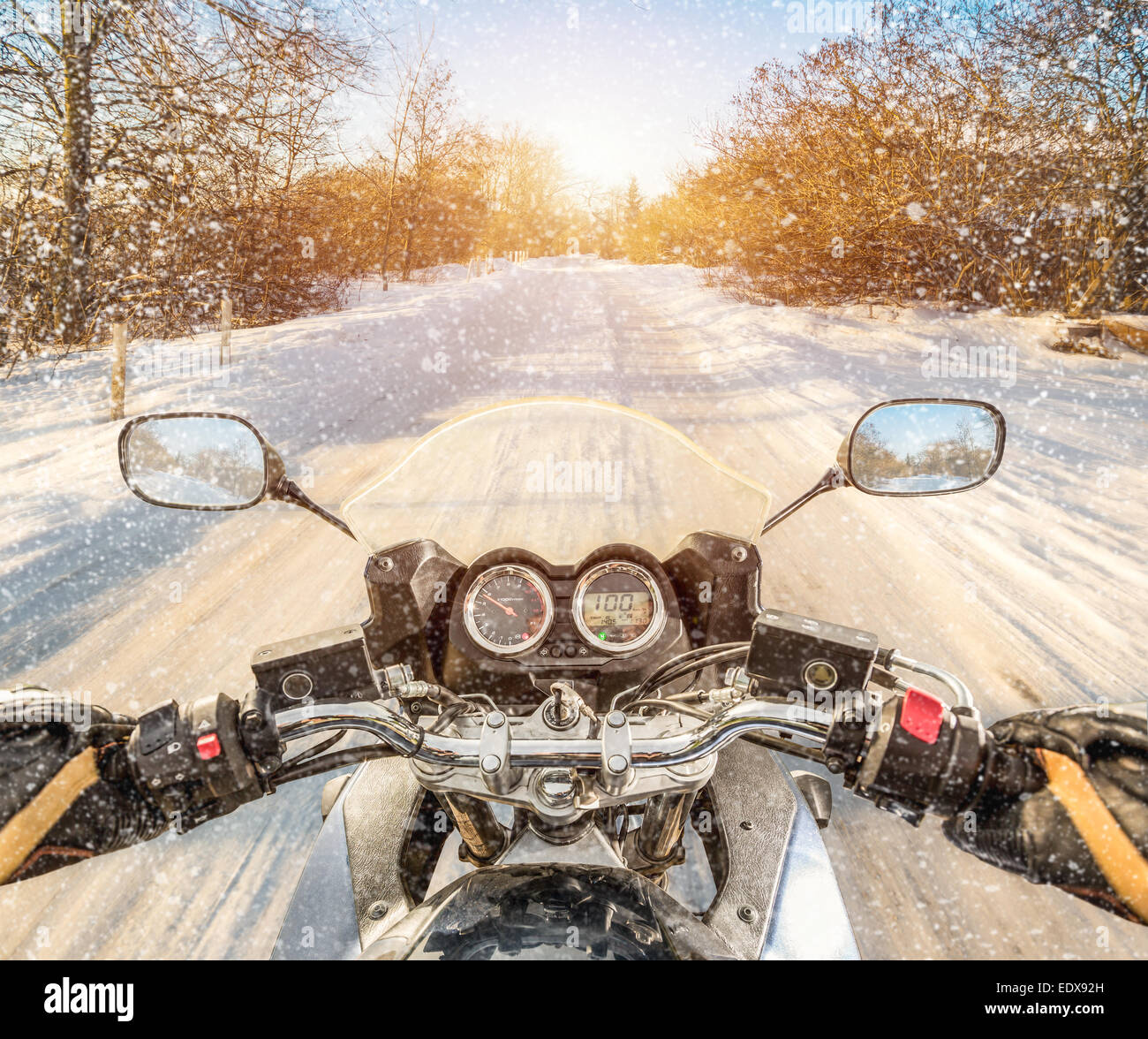 Biker rides on winter slippery road. First-person view. Stock Photo