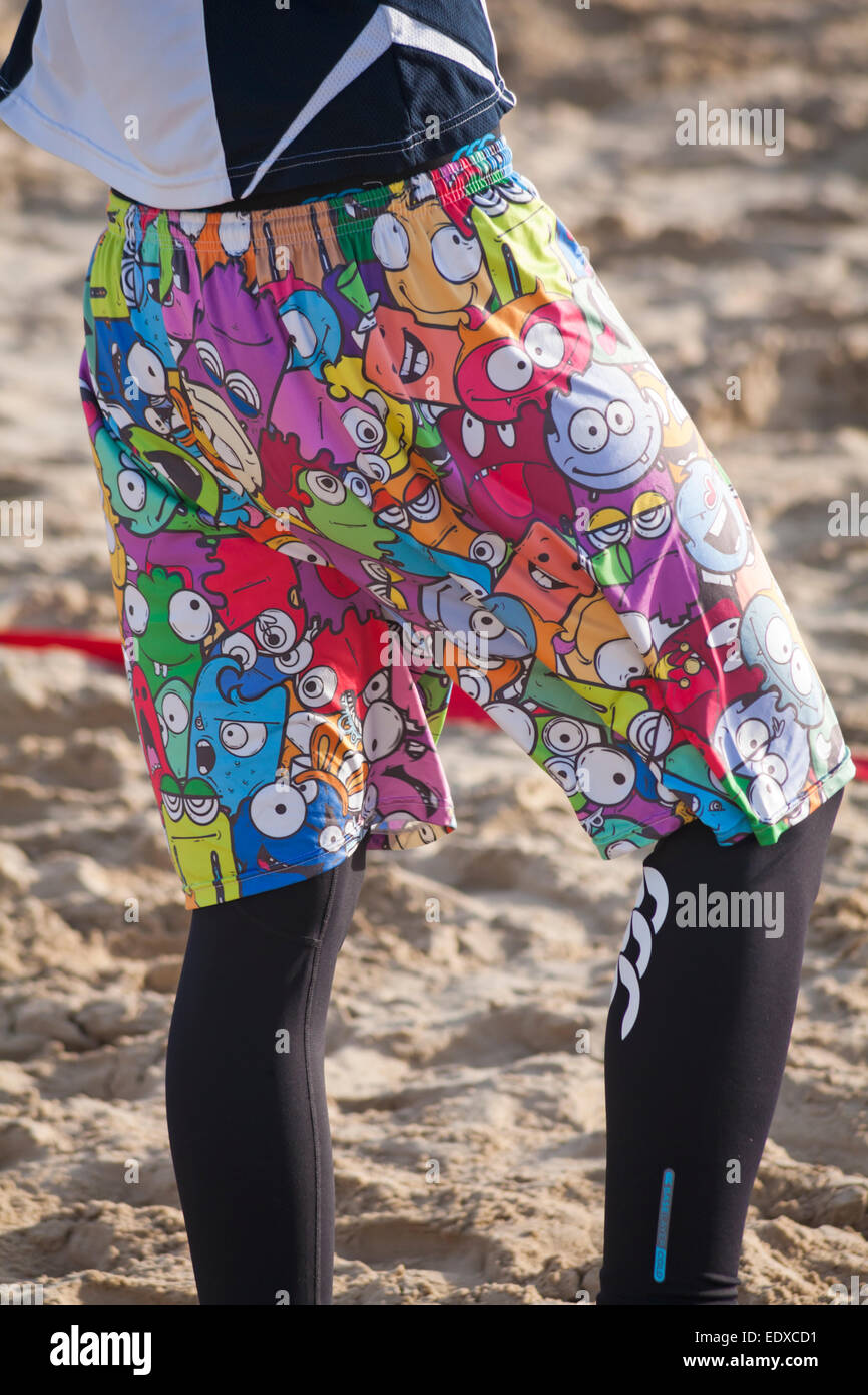 Sandbanks beach, Poole, Dorset, UK. 11th January, 2015. Ultimate Frisbee Beach Tournament takes place on Sandbanks beach with ten teams taking part, including four GB teams as part of their training towards the World Championships of Beach Ultimate. Man wearing Moshi Monsters shorts and leggings. Credit:  Carolyn Jenkins/Alamy Live News Stock Photo