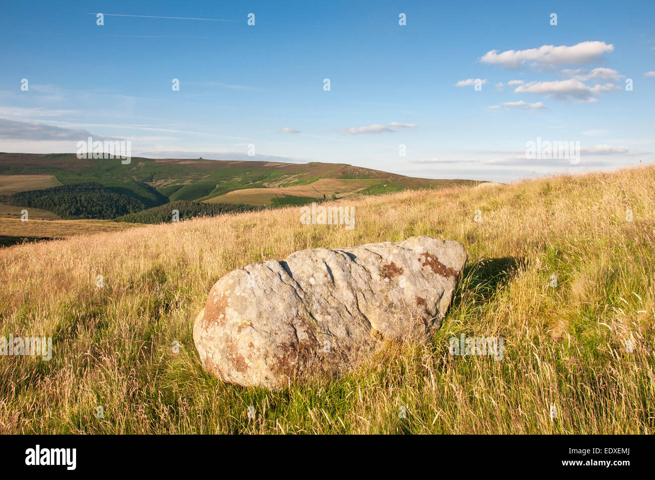 Boulder in the grass below Crook Hill in the Peak District on a beautiful summer evening. Stock Photo