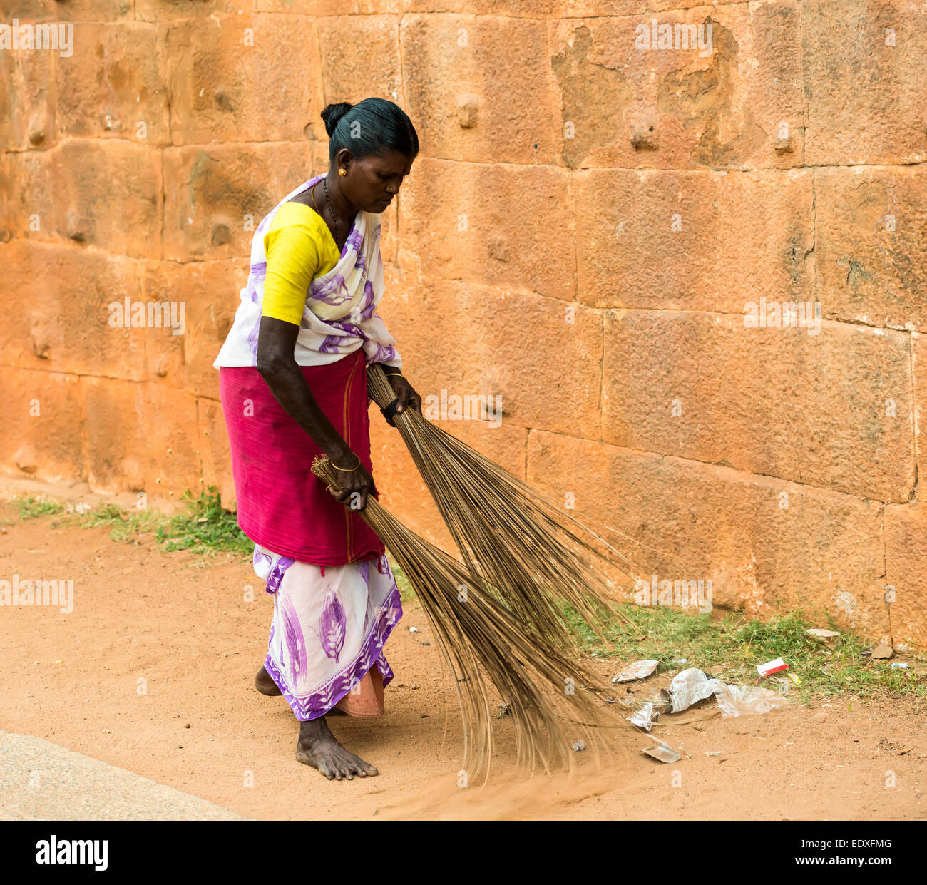 THANJAVUR, INDIA - FEBRUARY 14: An unidentified Indian woman in national dress carries sweeping the two brooms at Brihadishwara Stock Photo