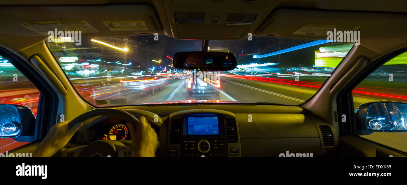 Night view out windshield of car while driving with blurred roadway and