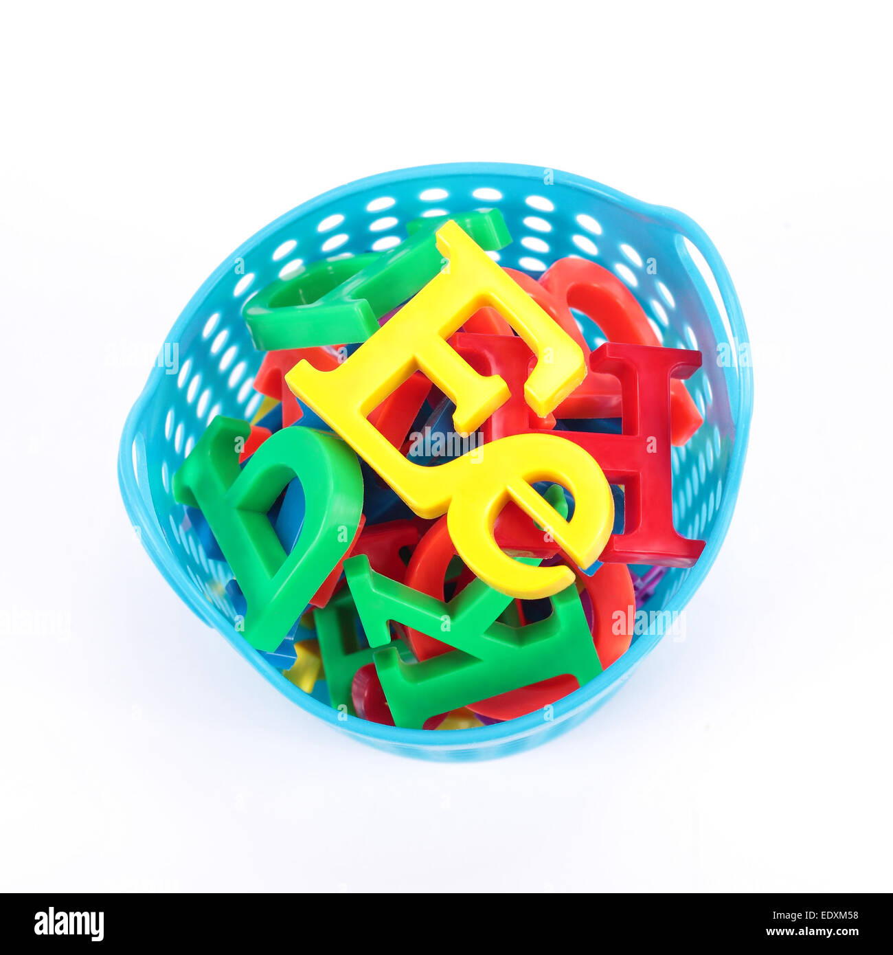 color letters of the alphabet in a children's blue bucket. On a white background Stock