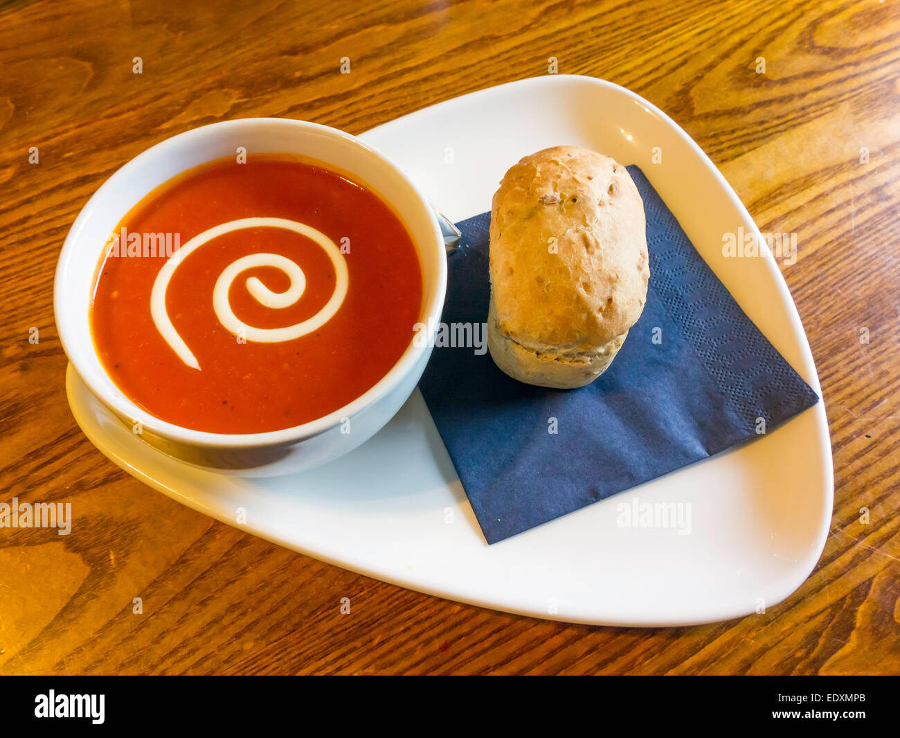 Pub Sunday lunch first course a bowl of tomato soup granary bread roll Stock Photo