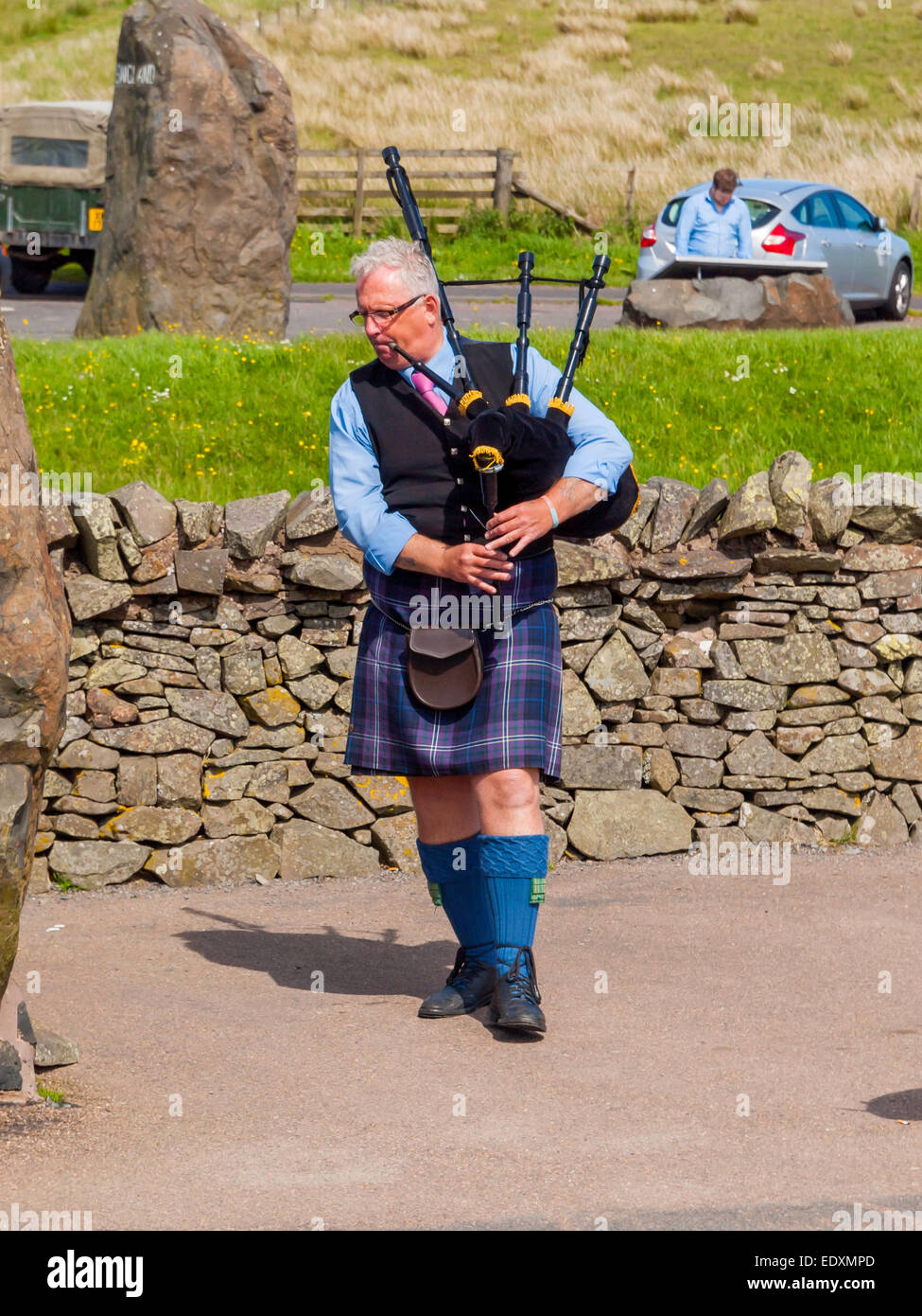 Man playing bagpipes at the England to Scotland border viewpoint at