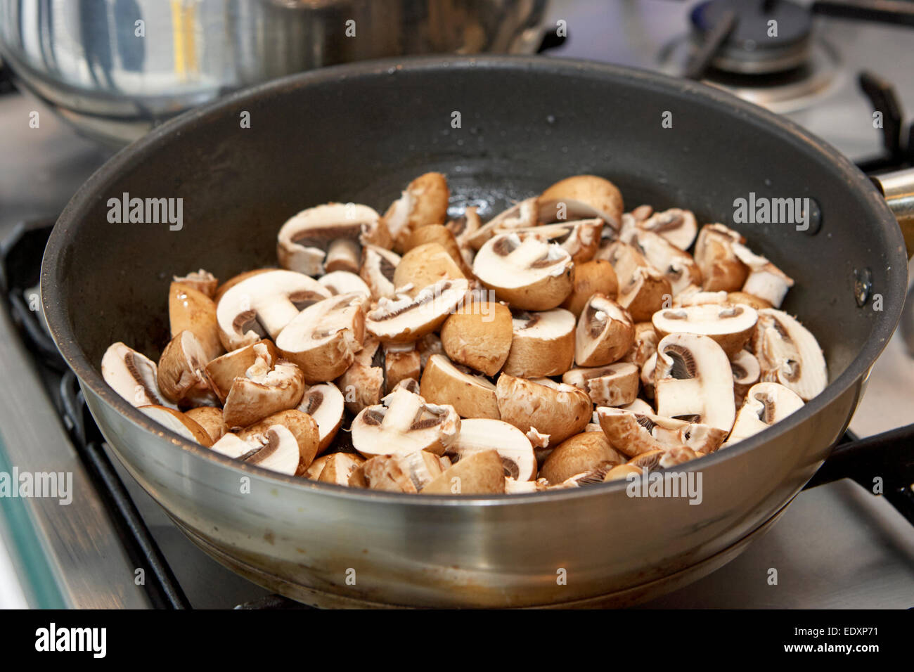 cooking sliced chestnut mushrooms in a pan Stock Photo Alamy