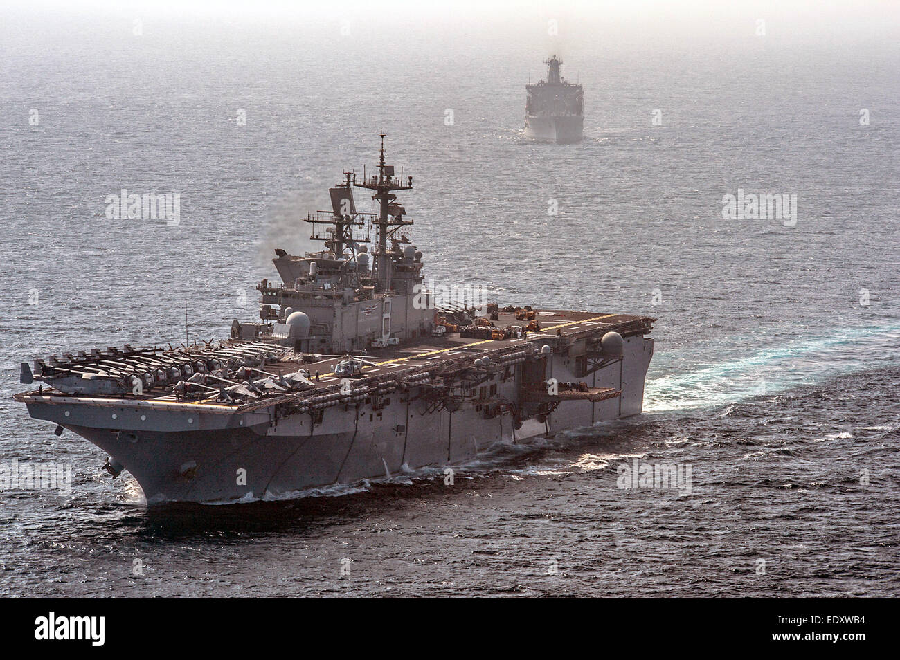 US Navy amphibious assault ship USS Makin Island and the amphibious dock landing ship USS Comstock during operations January 6, 2015 in the Arabian Sea. Stock Photo