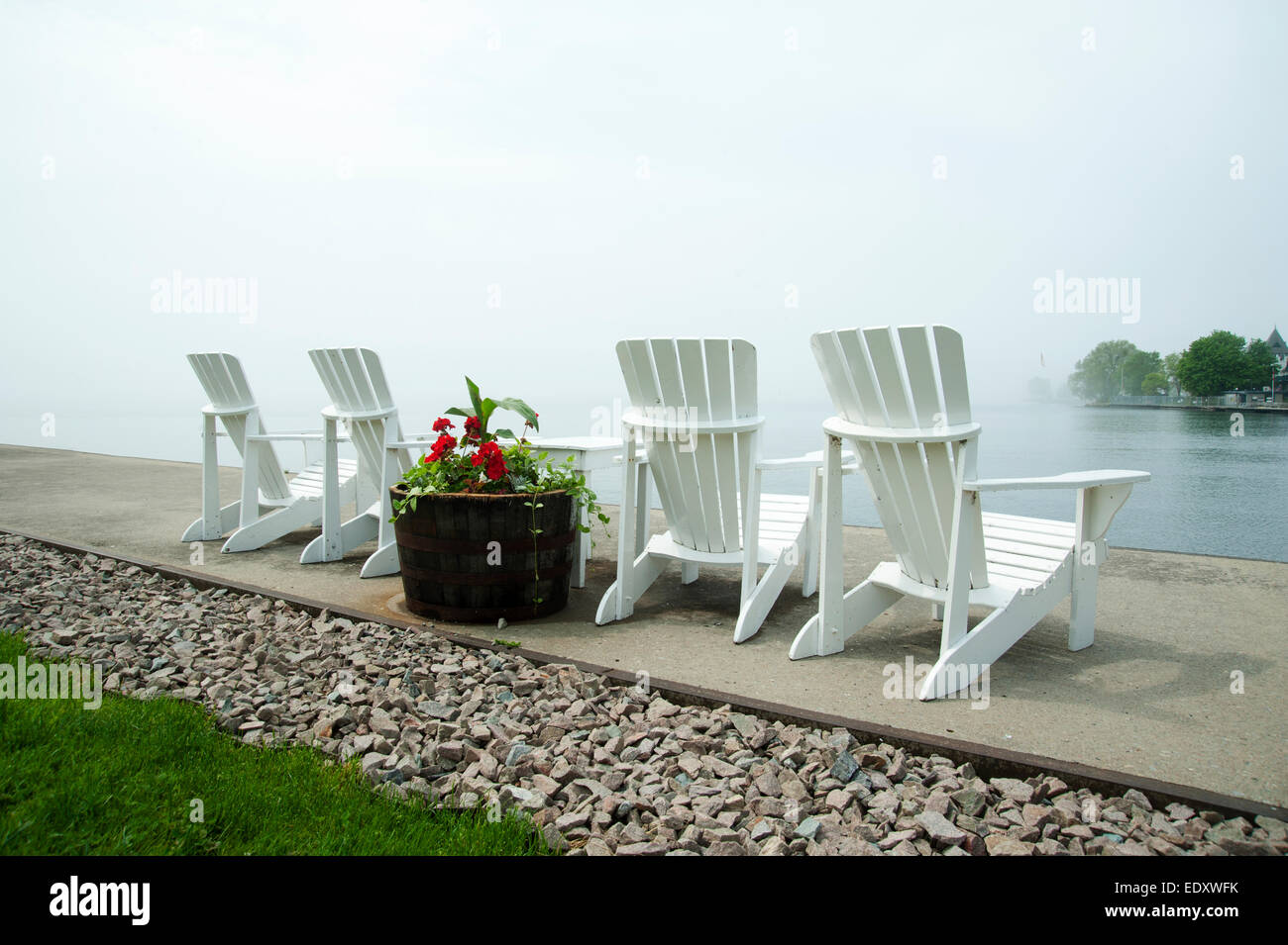 Lawn chairs on a dock with a view out over the St. Lawrence River, Gananoque, Ontario, Canada Stock Photo