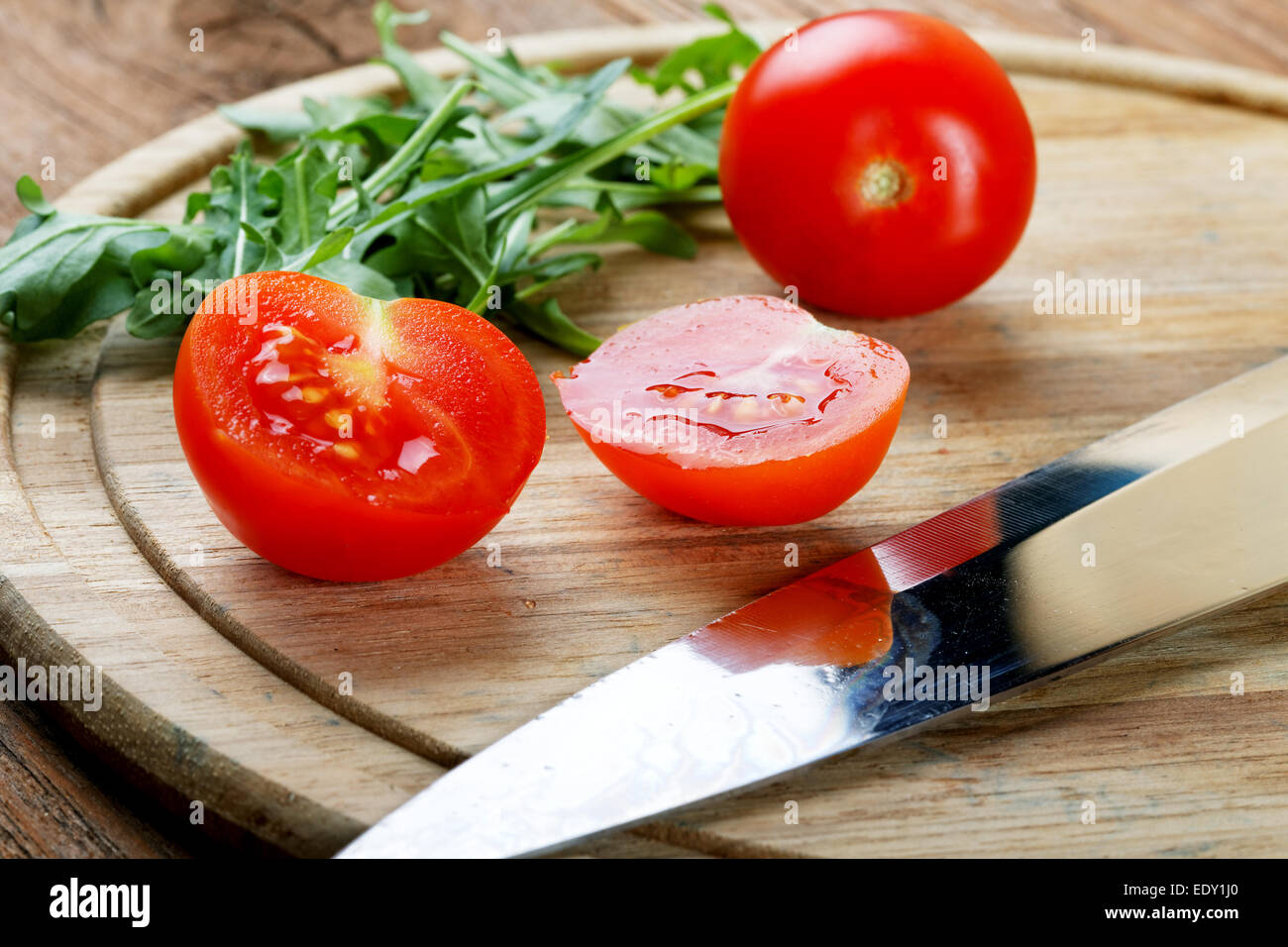 Tomatoes salad a knife on a chopping board Stock Photo - Alamy