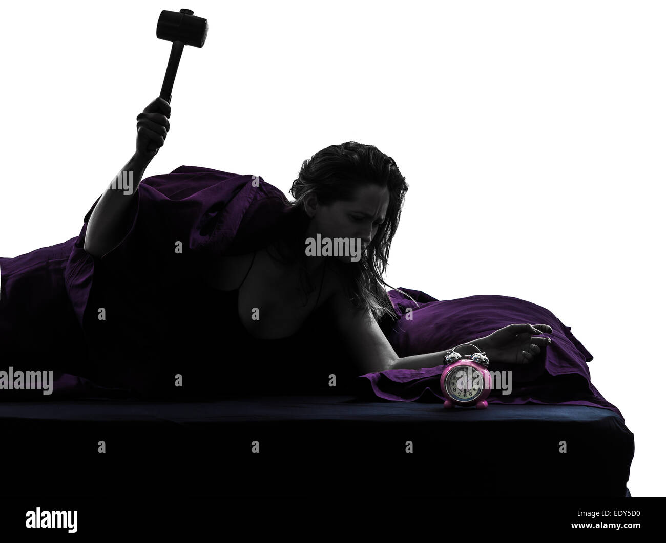 one woman in bed waking up smashing alarm clock silhouette studio on white background Stock Photo