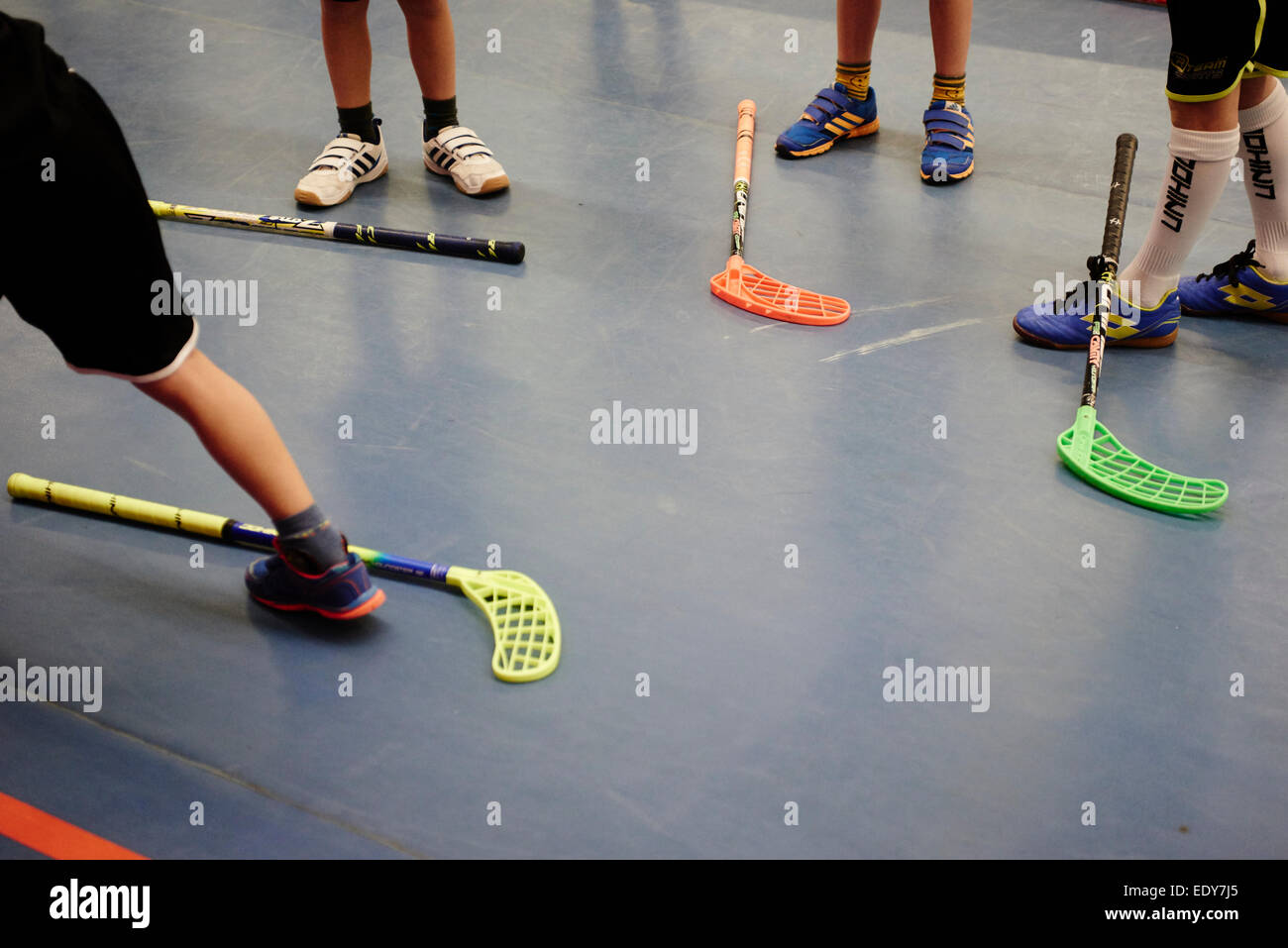 Children boys schoolchildren playing floorball (floor hockey) match in