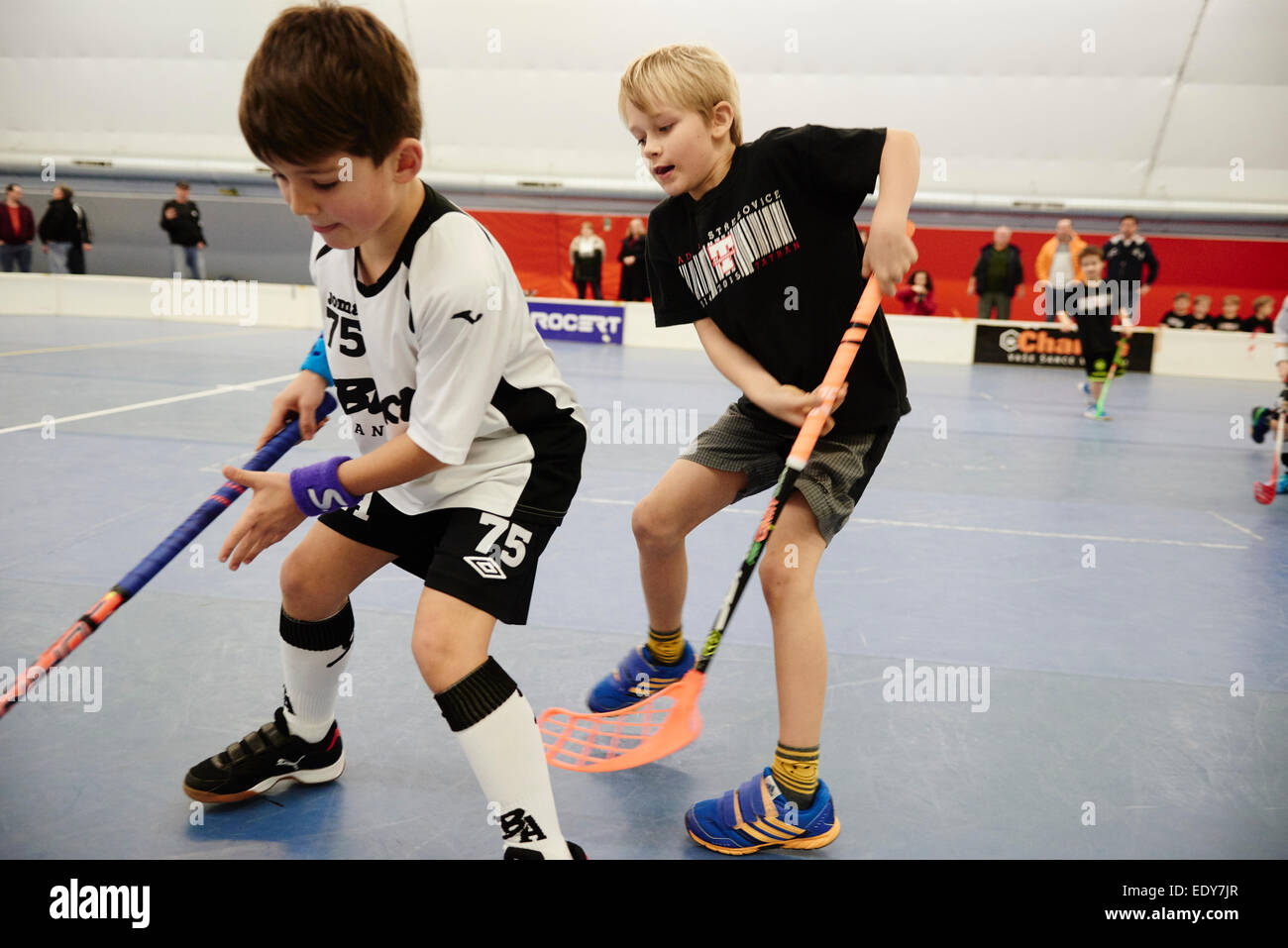 Children boys schoolchildren playing floorball (floor hockey) match in