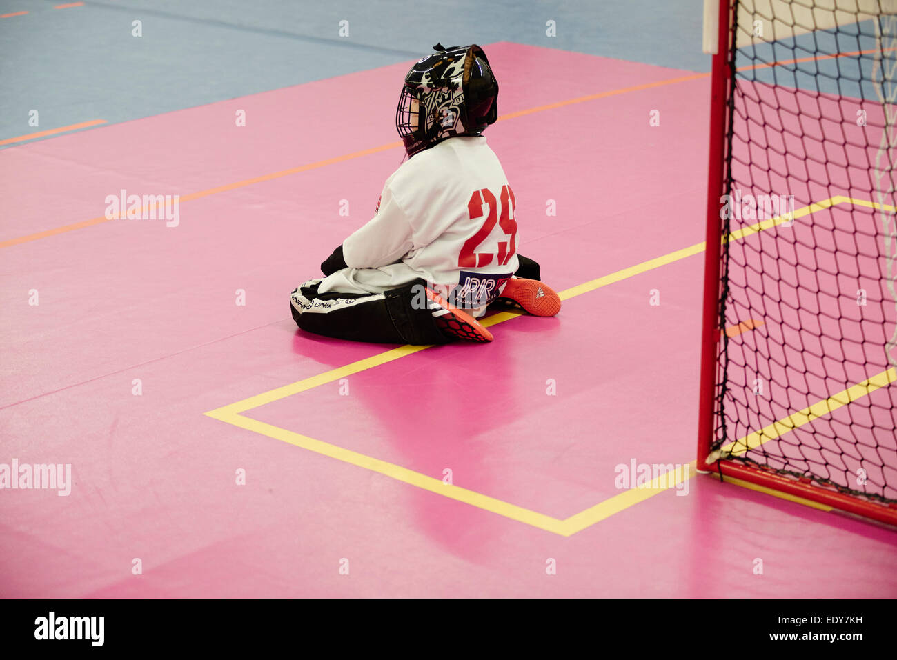 Children boys schoolchildren playing floorball (floor hockey) match in