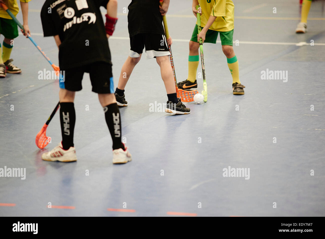 Children boys schoolchildren playing floorball (floor hockey) match in