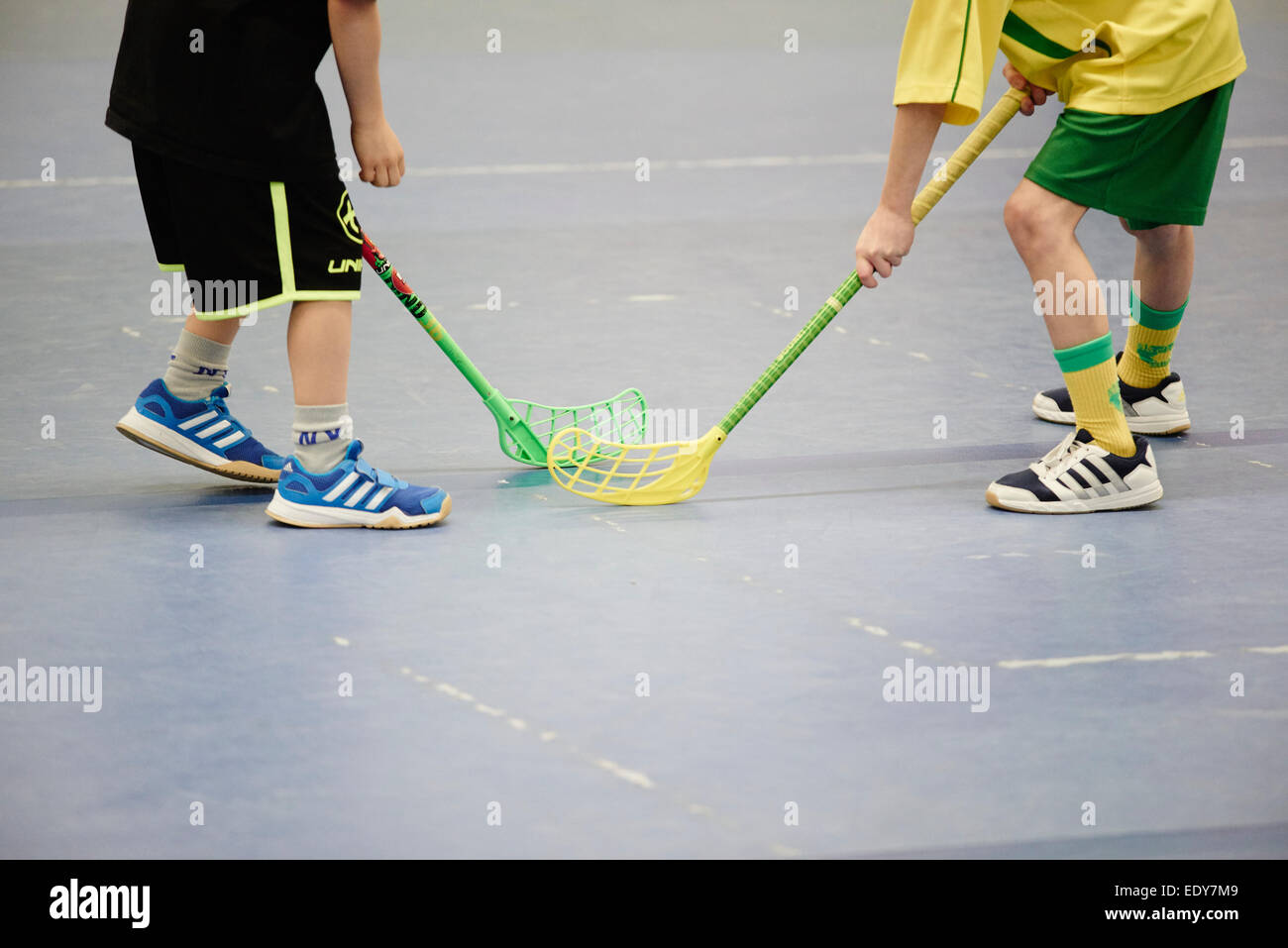 Children boys schoolchildren playing floorball (floor hockey) match in