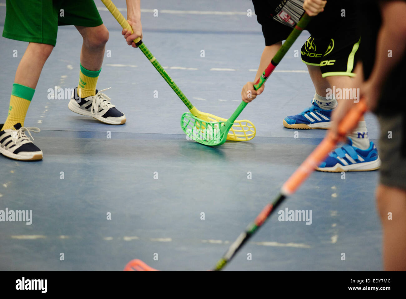 Children boys schoolchildren playing floorball (floor hockey) match in