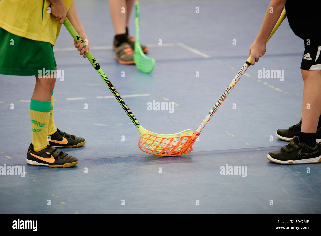 Children boys schoolchildren playing floorball (floor hockey) match in