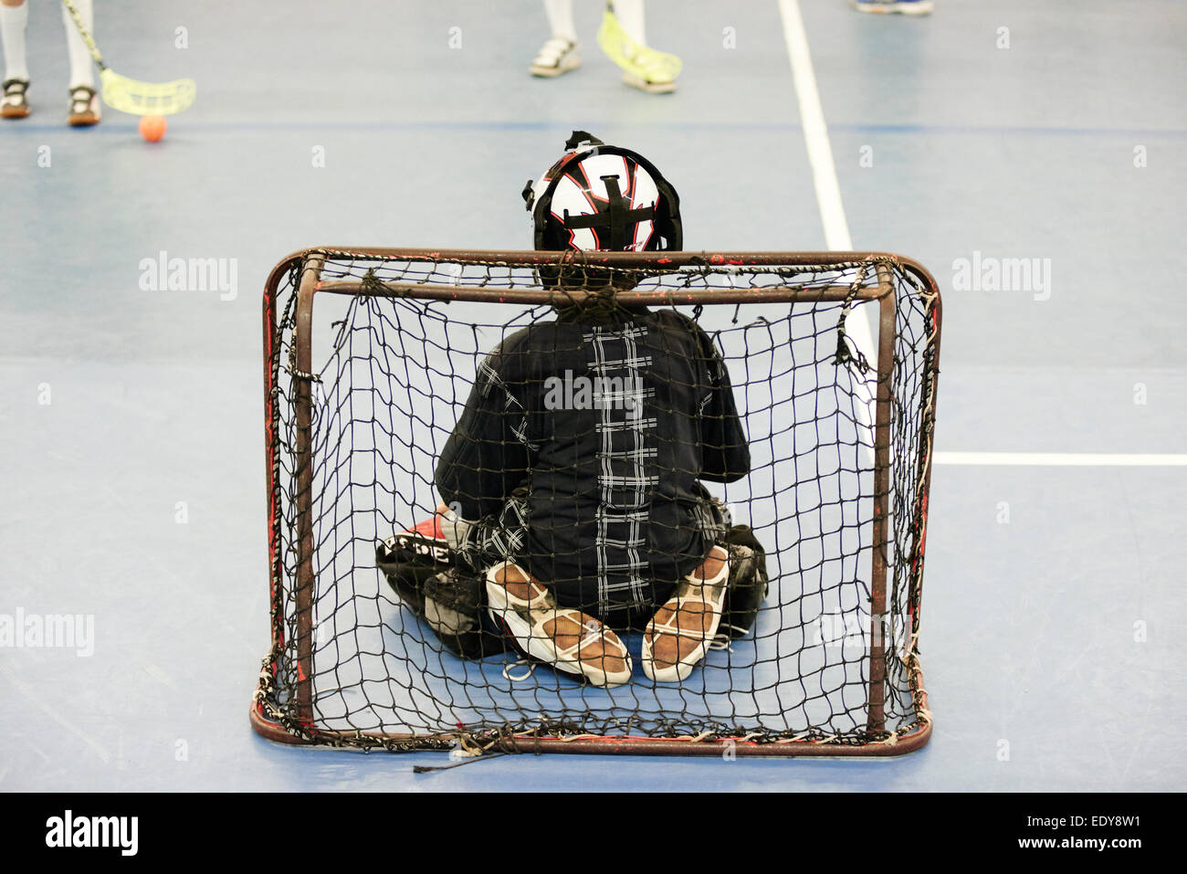 Children boys schoolchildren playing floorball (floor hockey) match in