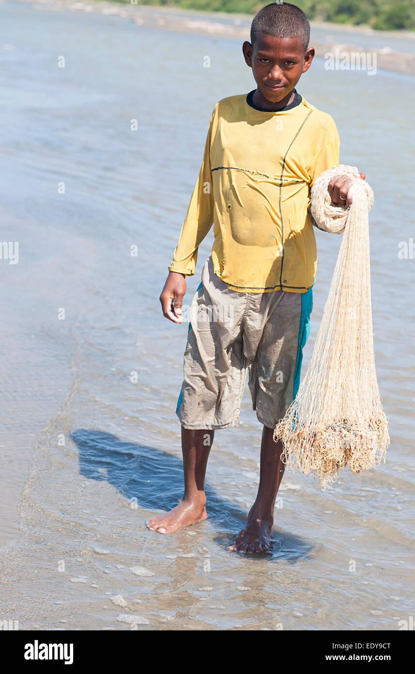 12 year old Colombian boy proudly holds fishing net showing result of his morning catch. Cartagena Colombia. Stock Photo